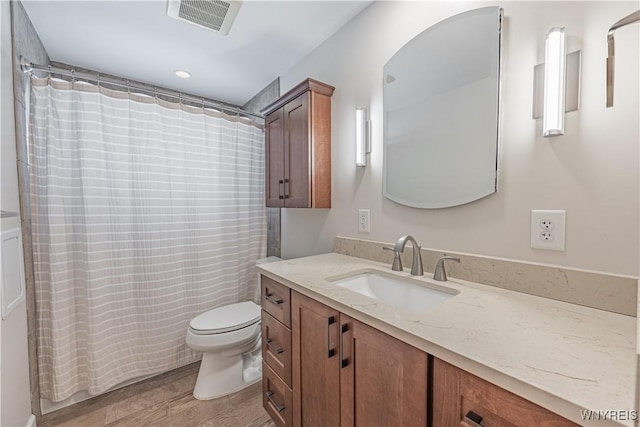 bathroom with vanity, wood-type flooring, and toilet