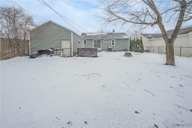 view of snow covered back of property