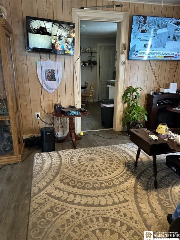 interior space with dark hardwood / wood-style flooring and wooden walls