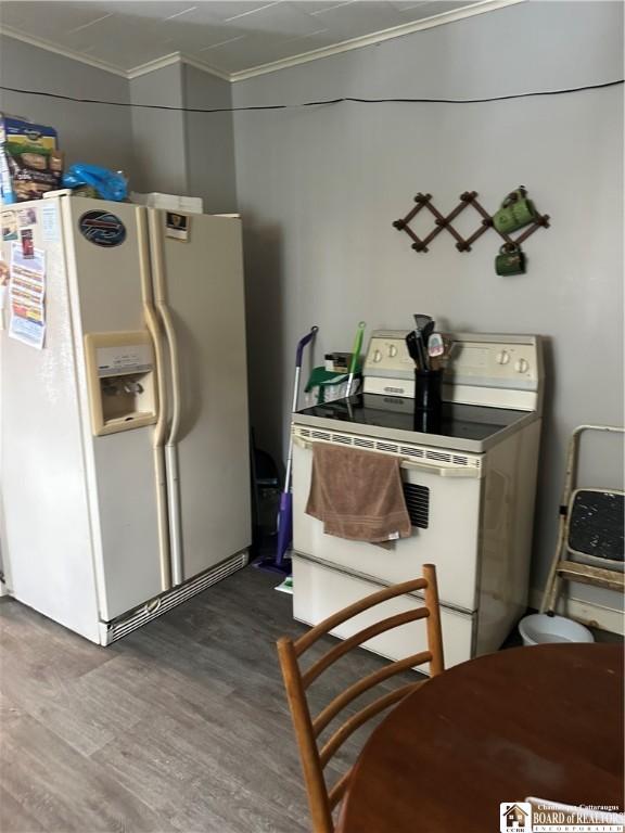 kitchen featuring crown molding, dark hardwood / wood-style flooring, and white appliances