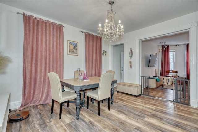 dining room with hardwood / wood-style floors and a chandelier