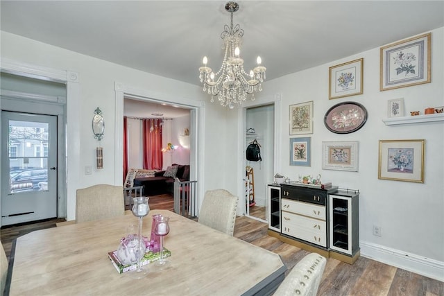 dining area featuring wood-type flooring and a chandelier