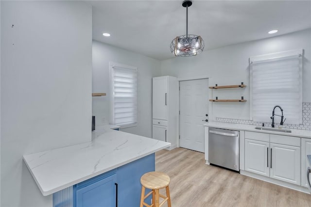 kitchen with sink, hanging light fixtures, dishwasher, kitchen peninsula, and white cabinets