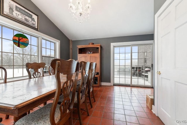 dining room with tile patterned floors, an inviting chandelier, a wealth of natural light, and lofted ceiling