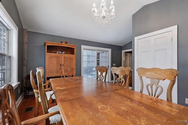 dining room with lofted ceiling and a chandelier