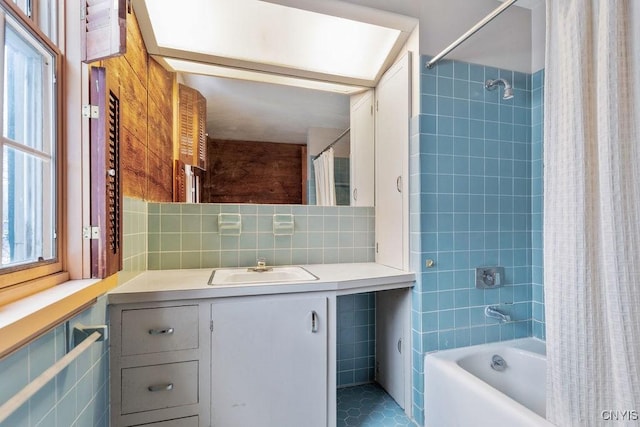 full bathroom with tile patterned flooring, vanity, shower / tub combo with curtain, tile walls, and backsplash