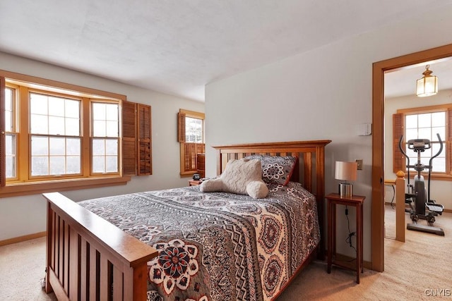 carpeted bedroom with baseboards and multiple windows