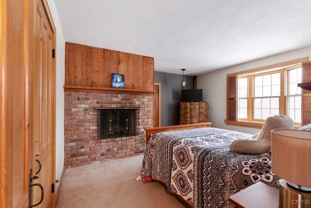 bedroom featuring light colored carpet and a brick fireplace