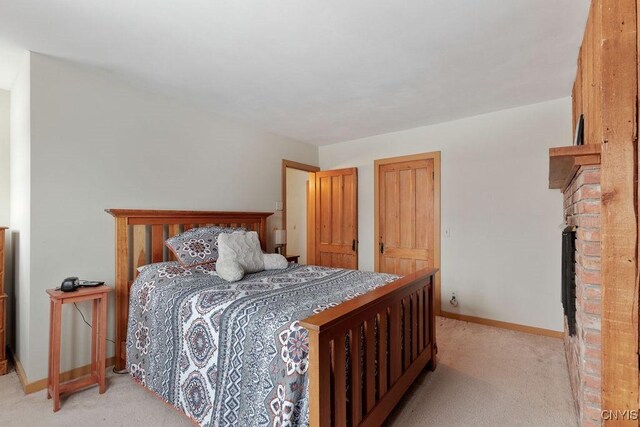 carpeted bedroom with a brick fireplace