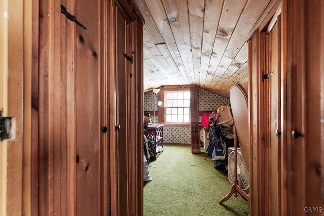 interior space with wood ceiling, vaulted ceiling, and carpet