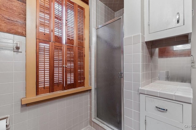 bathroom featuring tile walls and a stall shower