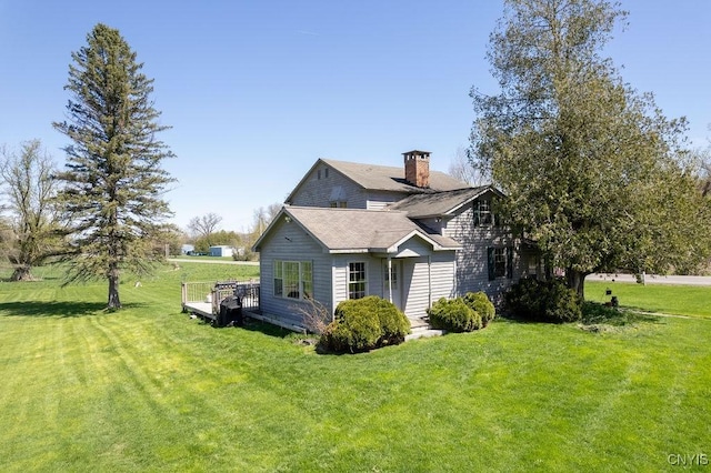 view of home's exterior with a lawn, a chimney, and a wooden deck