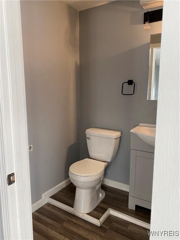 bathroom featuring wood-type flooring, toilet, and vanity