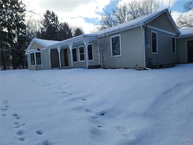 view of snow covered back of property