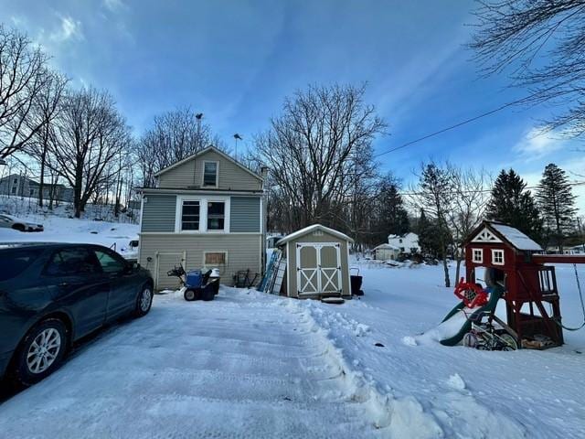 snow covered property featuring a storage shed