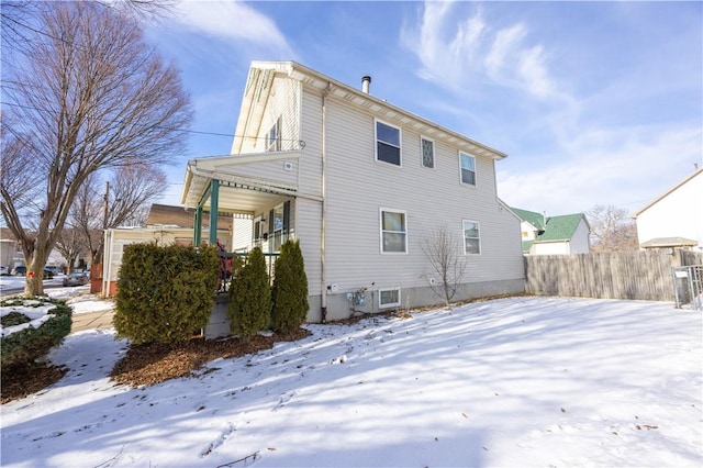 view of snow covered back of property