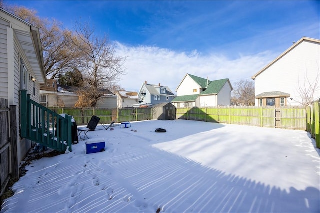 snowy yard with a storage shed