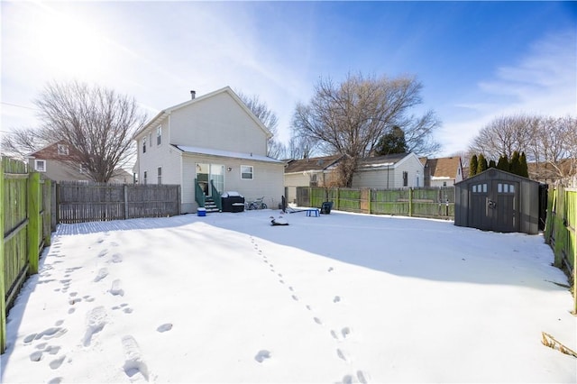 yard layered in snow featuring a storage unit