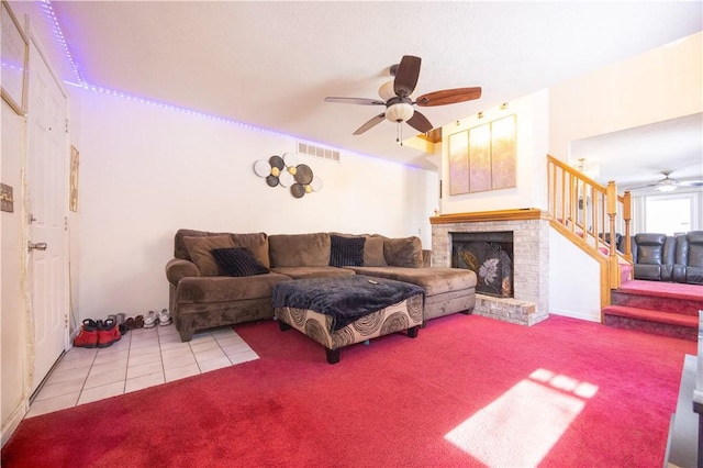 living room featuring light carpet, a fireplace, and ceiling fan