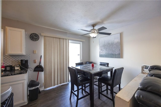 dining area with ceiling fan, dark hardwood / wood-style floors, and a textured ceiling