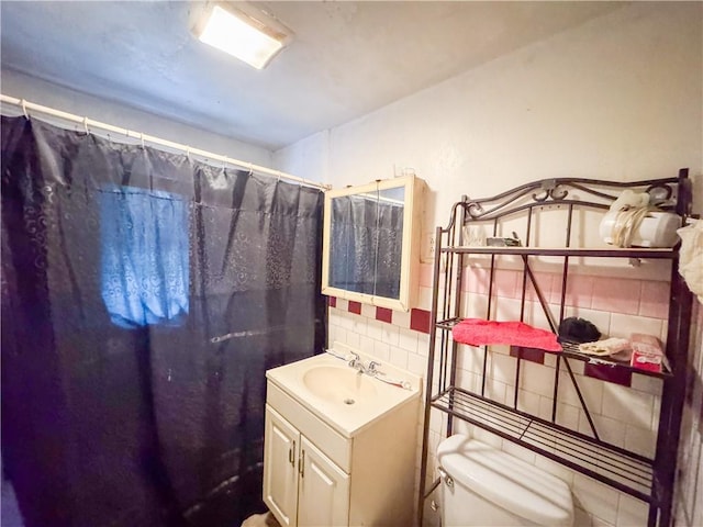 bathroom featuring vanity, toilet, curtained shower, and tile walls