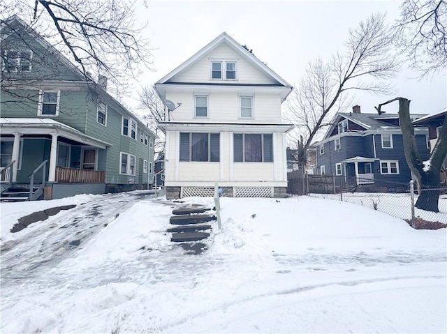 snow covered rear of property with a porch