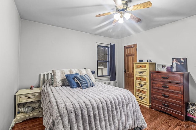 bedroom featuring dark hardwood / wood-style floors, radiator, and ceiling fan