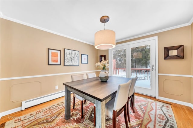 dining area featuring crown molding, wood-type flooring, and baseboard heating