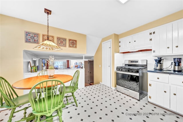 kitchen featuring white cabinetry, decorative backsplash, gas stove, and hanging light fixtures