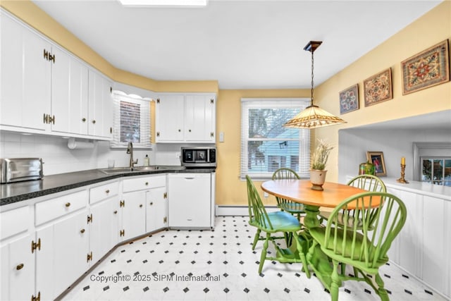 kitchen featuring sink, dishwasher, white cabinetry, decorative backsplash, and decorative light fixtures