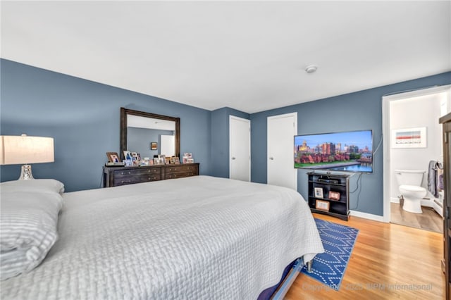 bedroom featuring hardwood / wood-style flooring and ensuite bath