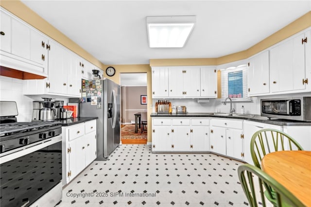 kitchen with stainless steel appliances, sink, decorative backsplash, and white cabinets