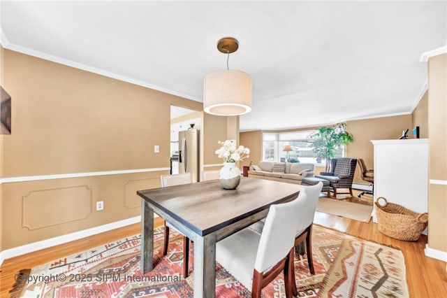 dining area featuring ornamental molding and hardwood / wood-style floors