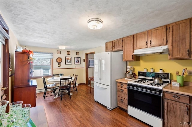 kitchen featuring white appliances, dark hardwood / wood-style floors, and a textured ceiling