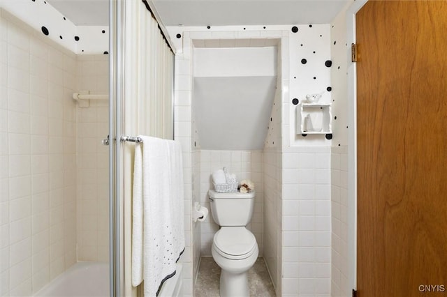 bathroom featuring tile walls and toilet