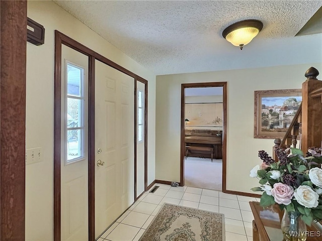 entryway featuring a textured ceiling and light tile patterned floors