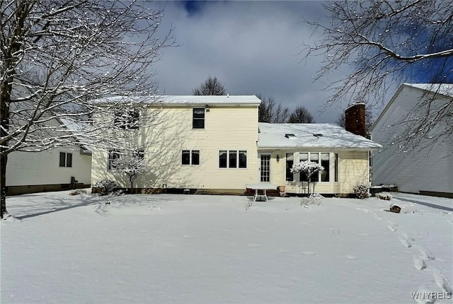 view of snow covered rear of property