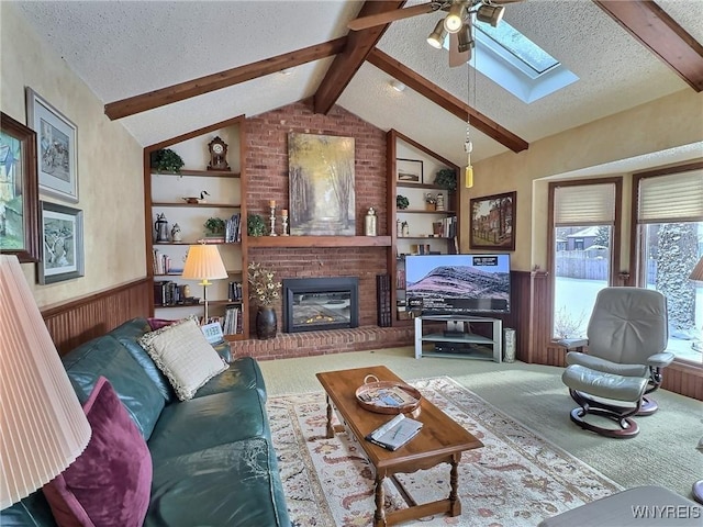 living room with lofted ceiling with skylight, carpet floors, a fireplace, and a textured ceiling