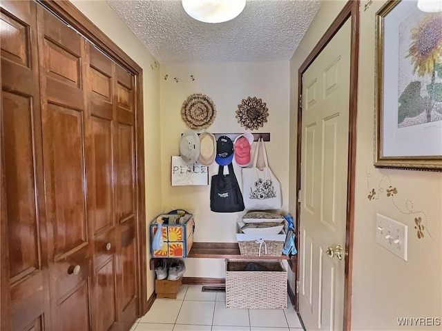 mudroom featuring light tile patterned floors and a textured ceiling