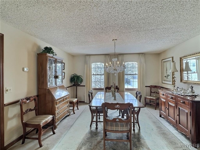 carpeted dining room featuring a notable chandelier and a textured ceiling