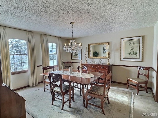 dining space with an inviting chandelier and a textured ceiling