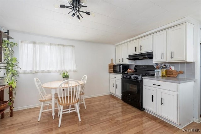 kitchen featuring white cabinetry, light wood-type flooring, tasteful backsplash, and black appliances