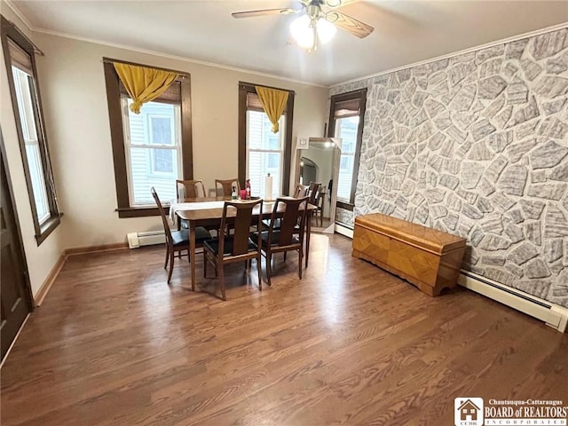 dining space with a baseboard radiator, dark wood-type flooring, ceiling fan, and crown molding