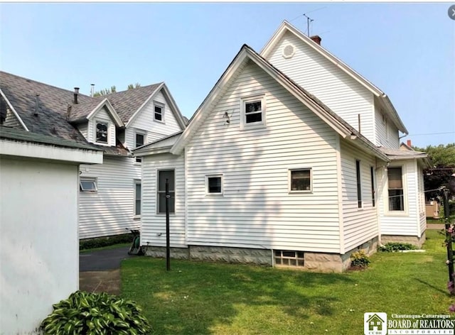 back of house with a lawn