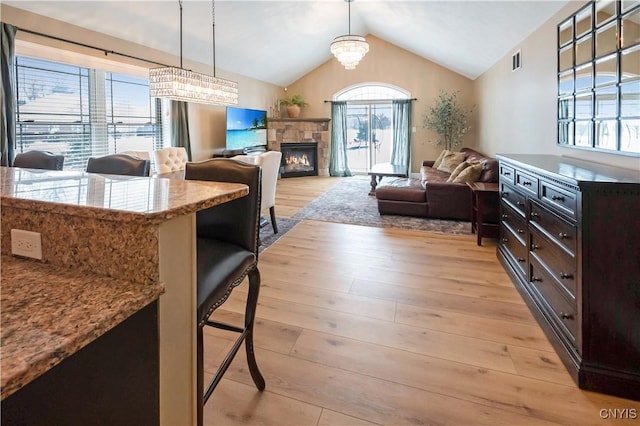 1771 Independence, Utica, NY 13502 - kitchen featuring dark brown cabinetry, light wood-type flooring, vaulted ceiling, visible vents, and open floor plan