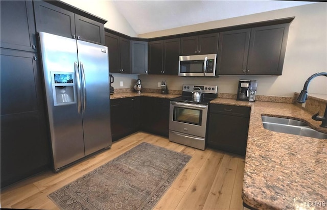 1771 Independence, Utica, NY 13502 - kitchen featuring light wood-style floors, vaulted ceiling, light stone counters, a sink, and stainless steel appliances
