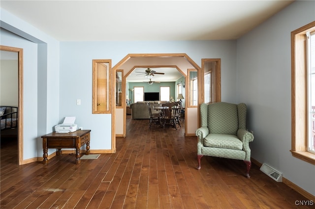 living area with ceiling fan and dark hardwood / wood-style flooring