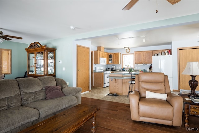 living room with sink, track lighting, ceiling fan, and light wood-type flooring