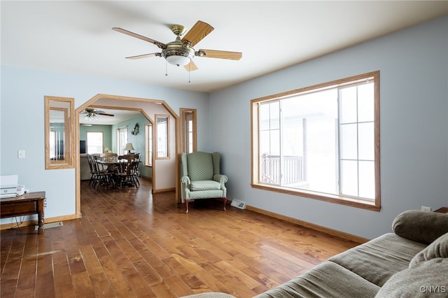 living room with ceiling fan and dark hardwood / wood-style flooring