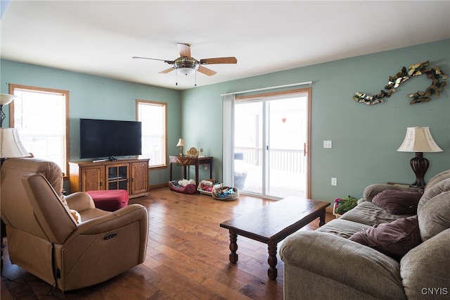 living room featuring dark wood-type flooring and ceiling fan